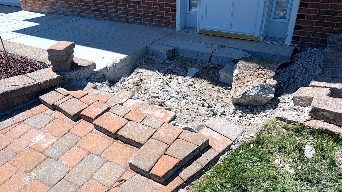 Hardscape demolition in progress, old concrete removed ahead of new paver install