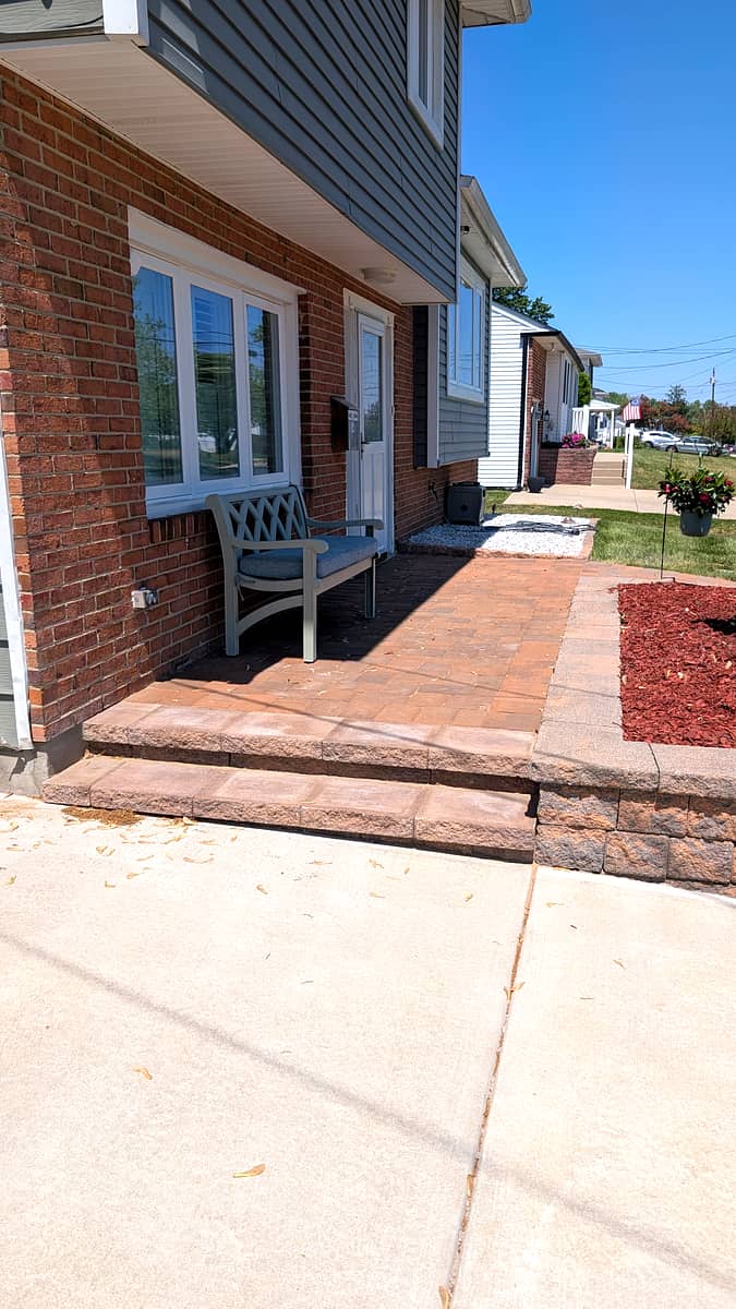After: rebuilt front entry with matching pavers, steps, and stone border