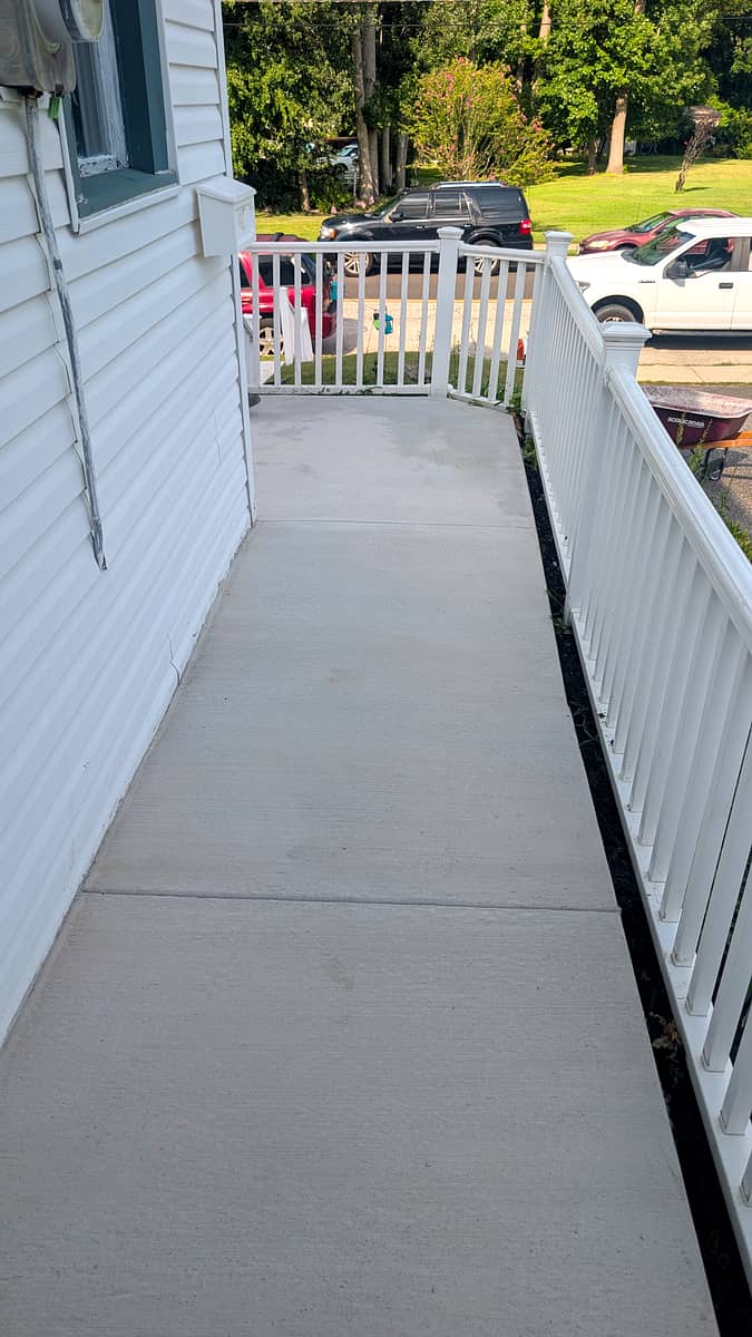 After: smooth new concrete side walkway along the house with clean mulched edges