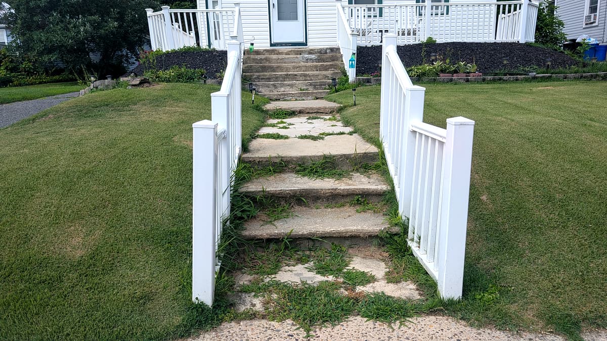 Before: cracked, crumbling concrete front steps with weeds growing through every joint, South Jersey home