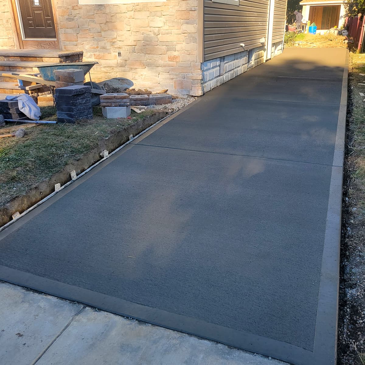 Freshly poured concrete driveway with decorative border