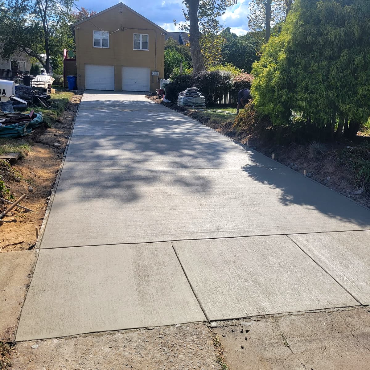Long concrete driveway leading to a detached garage