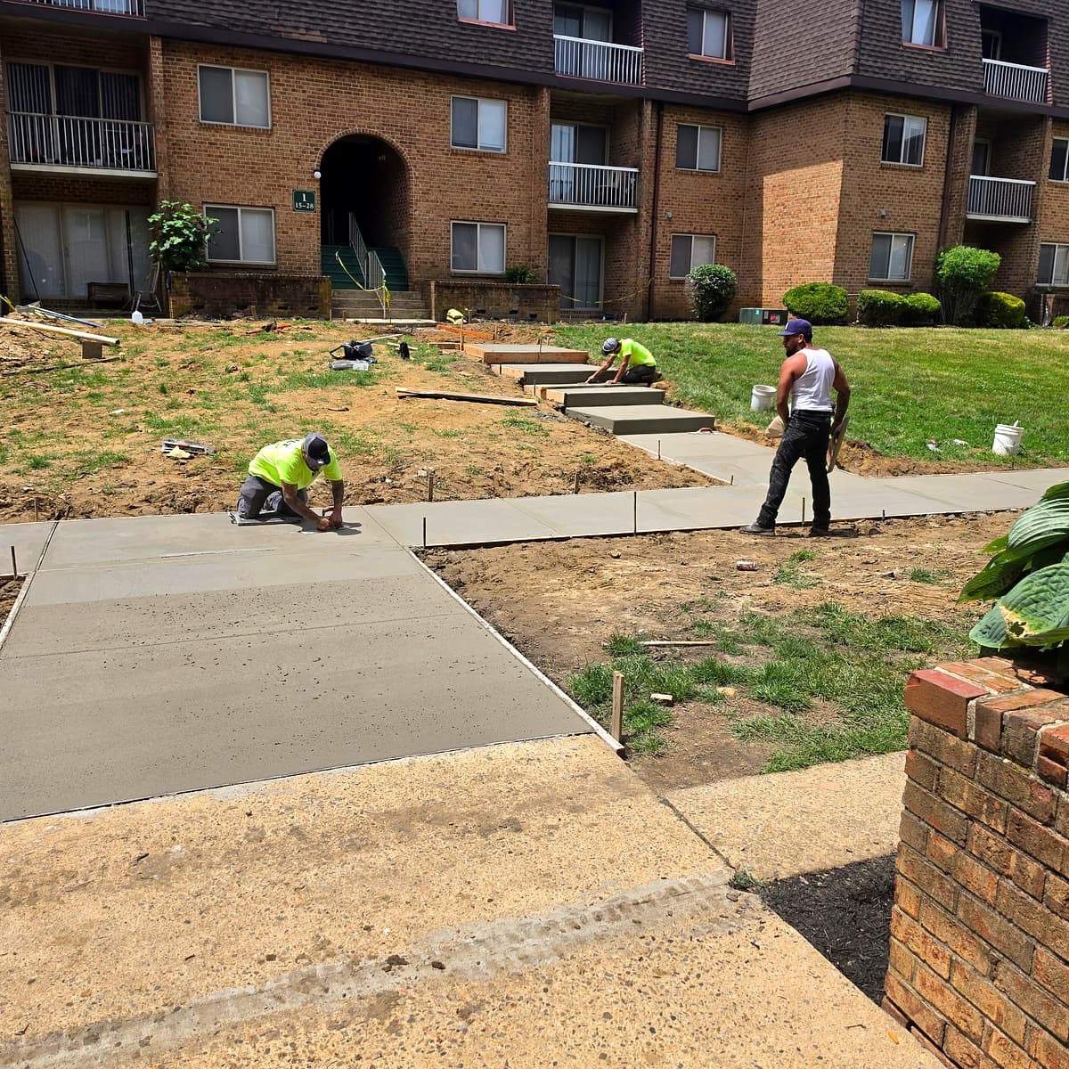 Crew pouring a new concrete walkway and steps