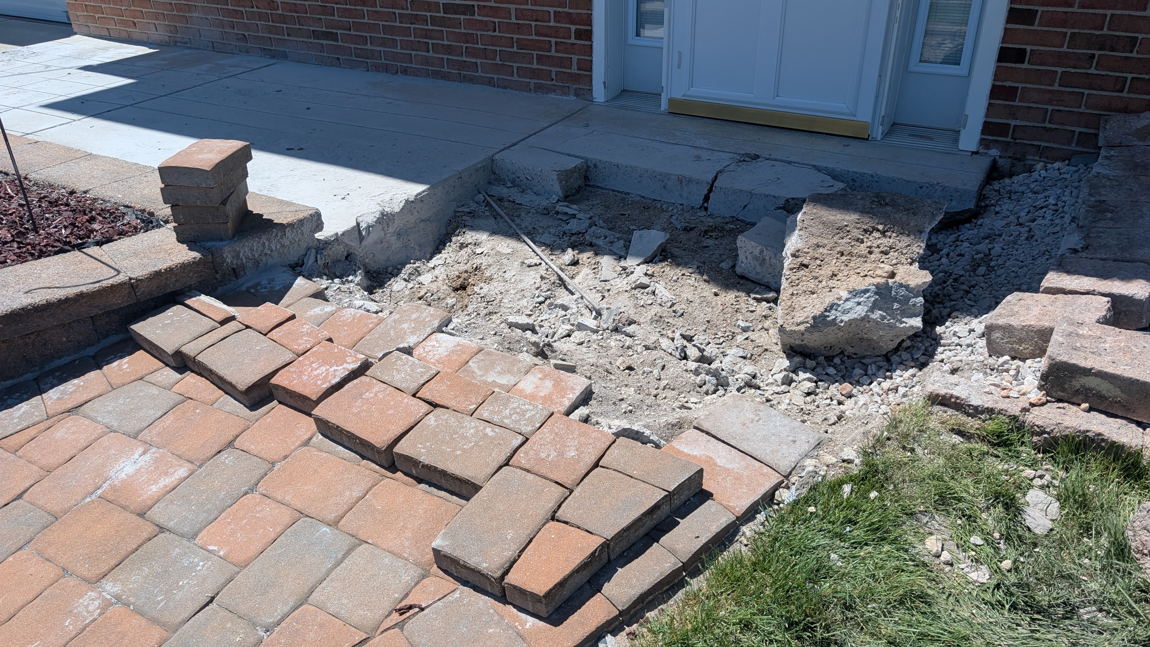 Hardscape demolition in progress, old concrete removed ahead of new paver install